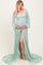 woman wearing a light mint green lace maternity gown with bell sleeves and a thigh-high slit, holding her baby bump