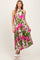 woman wearing a floral maternity dress with pink and green patterns, styled with a halter neck and pleated skirt