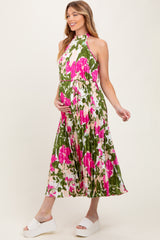 woman wearing a floral maternity dress with a high neck and flowing skirt, holding her baby bump