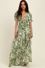 woman wearing a green floral maxi dress with puff sleeves and a tie front detail