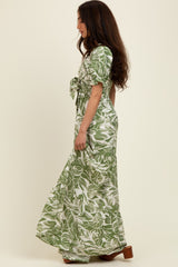 woman wearing a green floral maxi dress with short sleeves and a tied waist detail