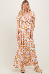 woman wearing a floral maxi dress with puff sleeves and a tie front detail