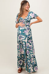 woman wearing a floral print maternity maxi dress with short ruffles and a visible baby bump