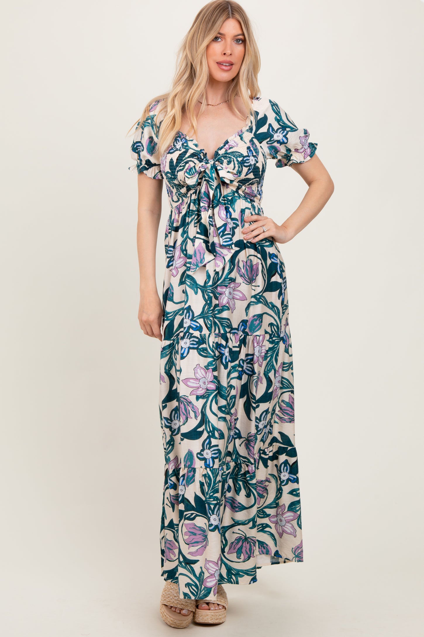 woman wearing a floral print maxi dress with short puff sleeves and a tie-front detail