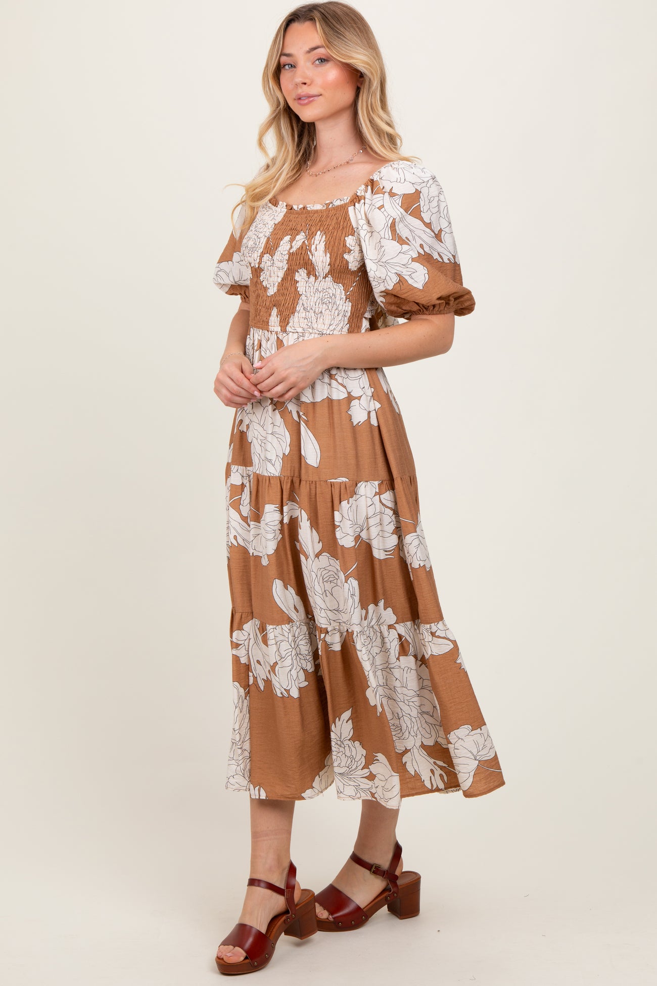 woman wearing a brown floral maxi dress with short puff sleeves and a smocked bodice