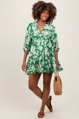 woman wearing a green floral maternity dress with a v-neck and balloon sleeves, holding a woven bag and showing her baby bump