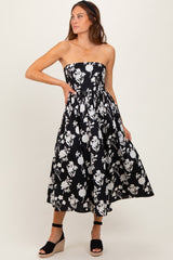 woman wearing a black and white floral strapless midi dress with a flared skirt and wedge sandals