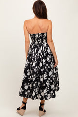 woman wearing a strapless black and white floral midi dress with a smocked bodice and flowy skirt