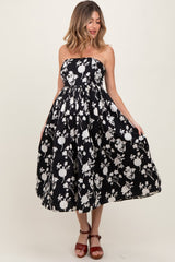 woman wearing a black and white floral strapless maternity dress with a full skirt and a flowing silhouette