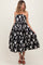 woman wearing a black and white floral strapless maternity dress with a full skirt and a flowing silhouette