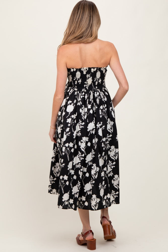 woman wearing a black and white floral strapless maternity dress with a smocked bodice and a flowy midi skirt