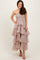 woman wearing a strapless nude tiered maxi dress with a smocked bodice and wavy ruffles