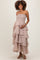 woman wearing a strapless blush maternity maxi dress with layered ruffles and holding her baby bump