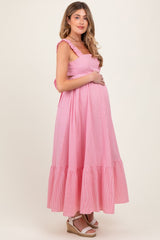 woman wearing a pink and white striped maternity maxi dress with ruffled straps and a visible baby bump