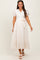 woman wearing a cream maternity dress with puff sleeves, button front, and tie waist detail