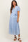 woman wearing a light blue maternity dress with puff sleeves, buttons, and a tied waist detail