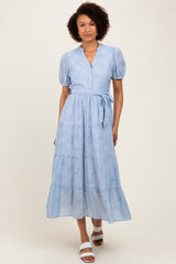 woman wearing a light blue tiered maxi dress with puff sleeves and buttons, styled with white sandals
