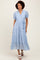 woman wearing a light blue tiered maxi dress with puff sleeves and buttons, styled with white sandals