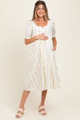 woman wearing a floral print maternity dress with puff sleeves and a button-down front, holding her baby bump