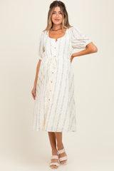 woman wearing a cream floral maternity midi dress with puff sleeves and button front, showcasing her baby bump