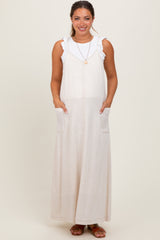 woman wearing a cream-colored maternity maxi dress with frill straps and side pockets