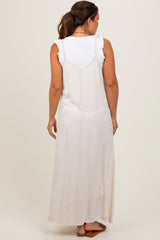 woman wearing a maternity cream maxi dress over a white ruffled top, viewed from the back