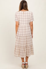 woman wearing a checkered tiered midi dress with short sleeves and a keyhole back detail