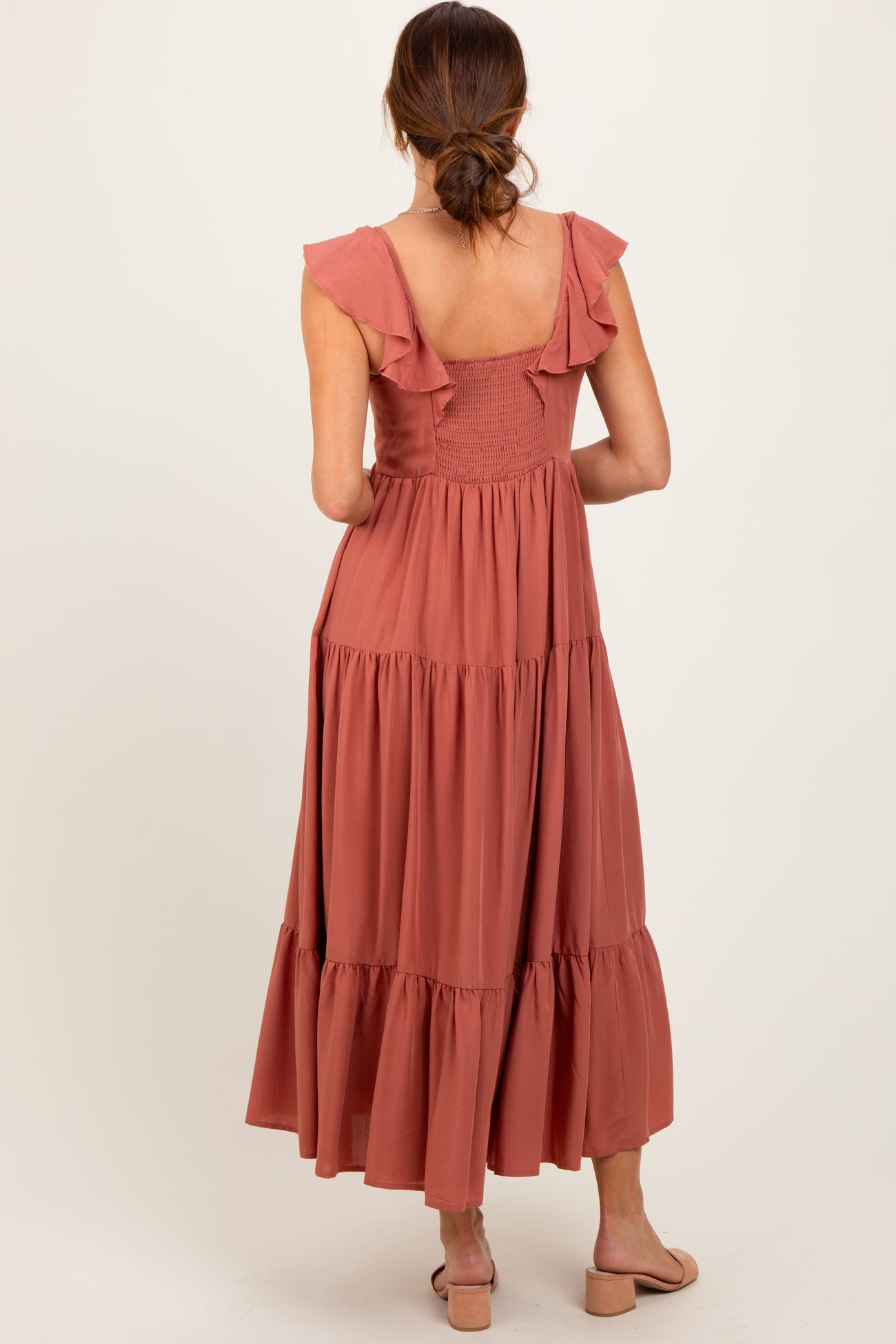woman wearing a dusty rose maxi dress with ruffle straps and tiered skirt from the back