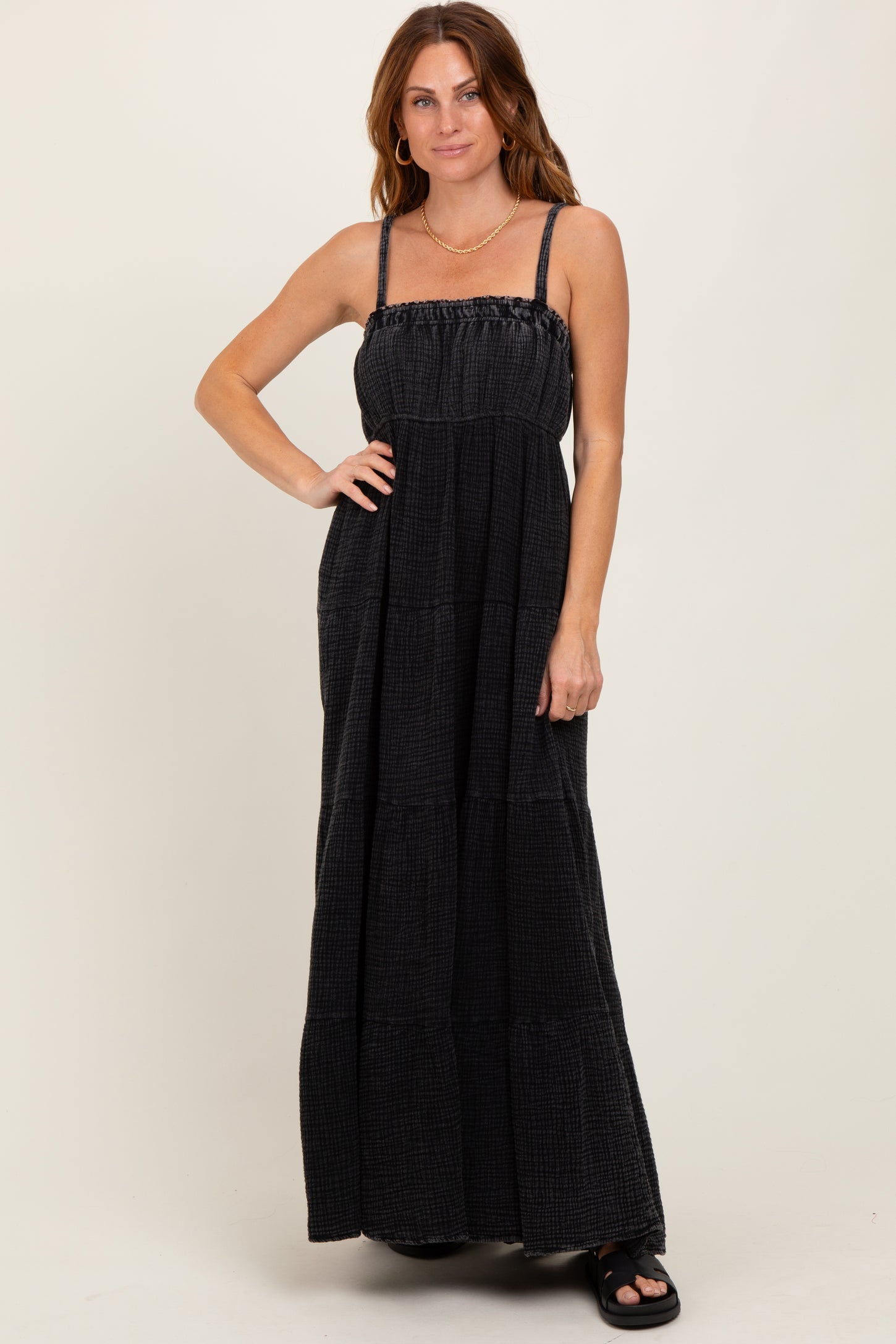 woman wearing a black tiered maxi dress with spaghetti straps and a smocked bodice
