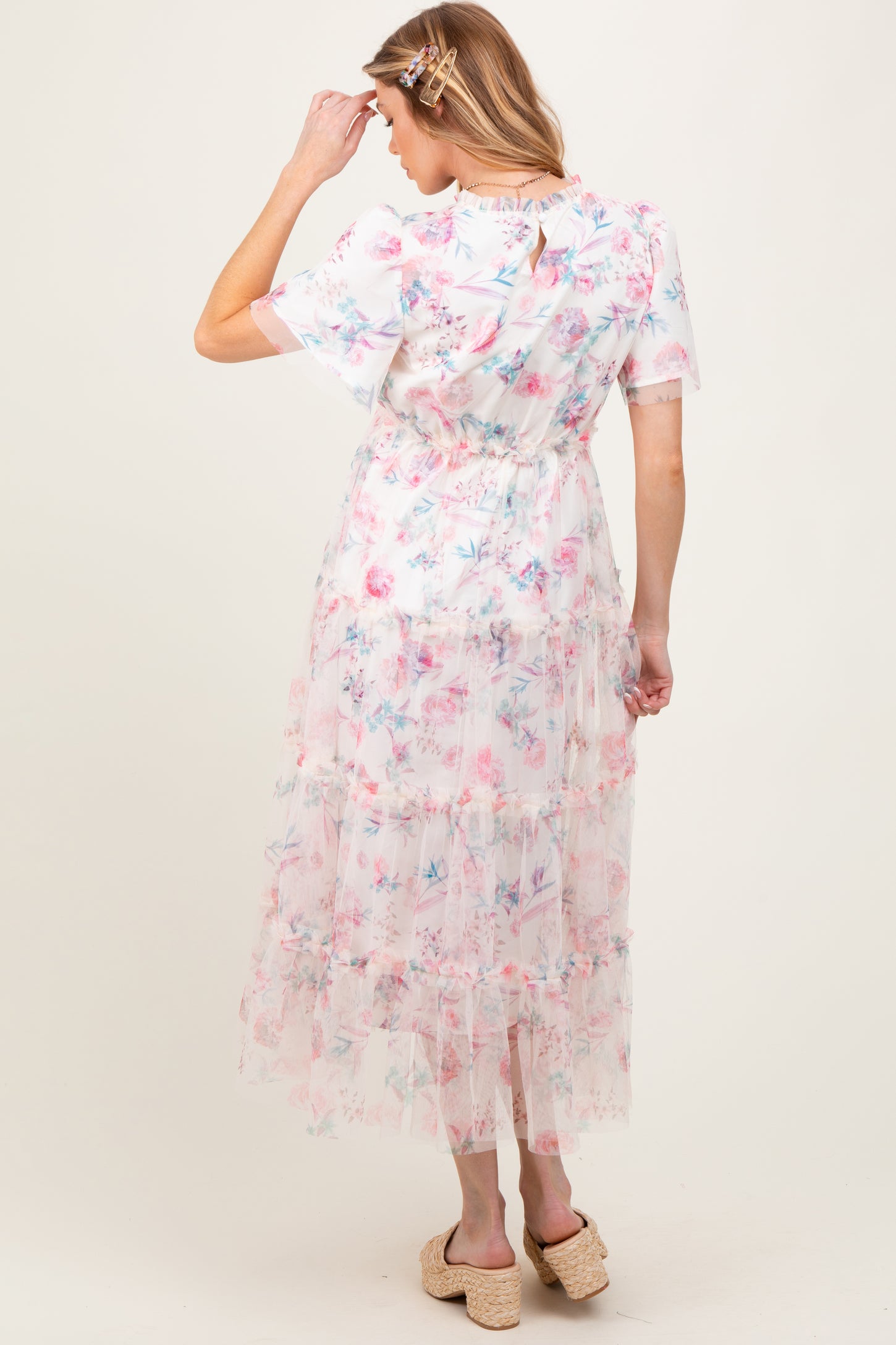 woman wearing a floral maternity maxi dress with tiers and short sleeves, viewed from the back