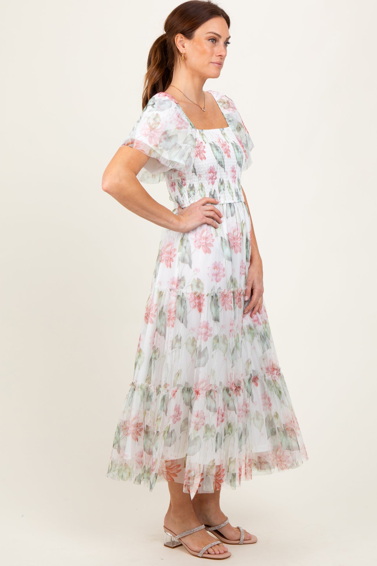 woman wearing a floral sheer maxi dress with short ruffled sleeves and a square neckline