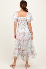 woman wearing a floral print maxi dress with puff sleeves and a smocked back design