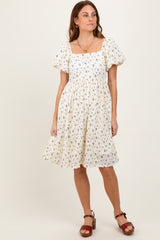 woman wearing a cream floral print puff sleeve dress with a square neckline and a flared skirt