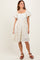 woman wearing a cream floral print puff sleeve dress with a square neckline and a flared skirt