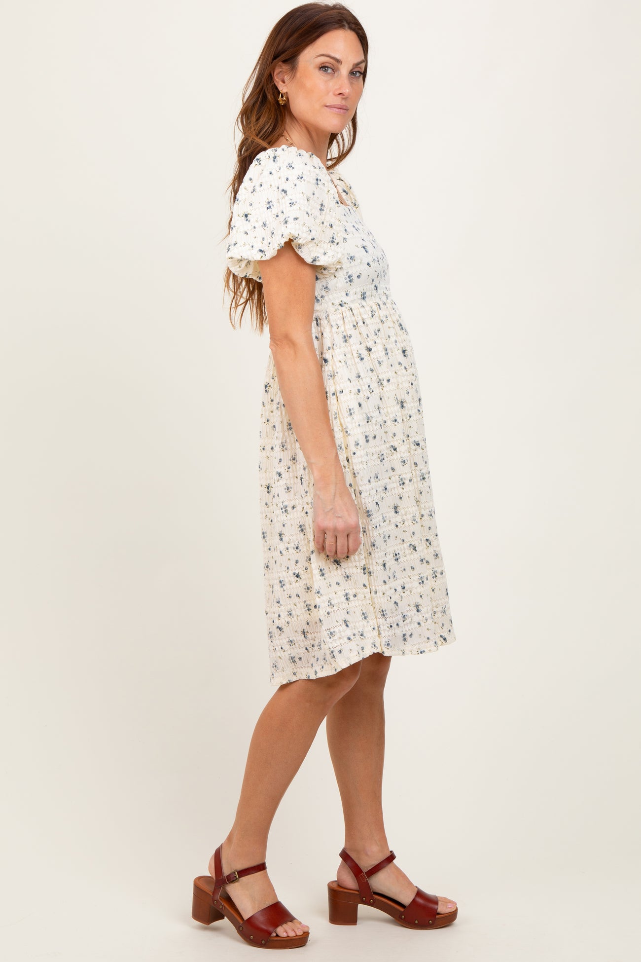 woman wearing a floral print short sleeve dress with a gathered waist and brown heeled sandals