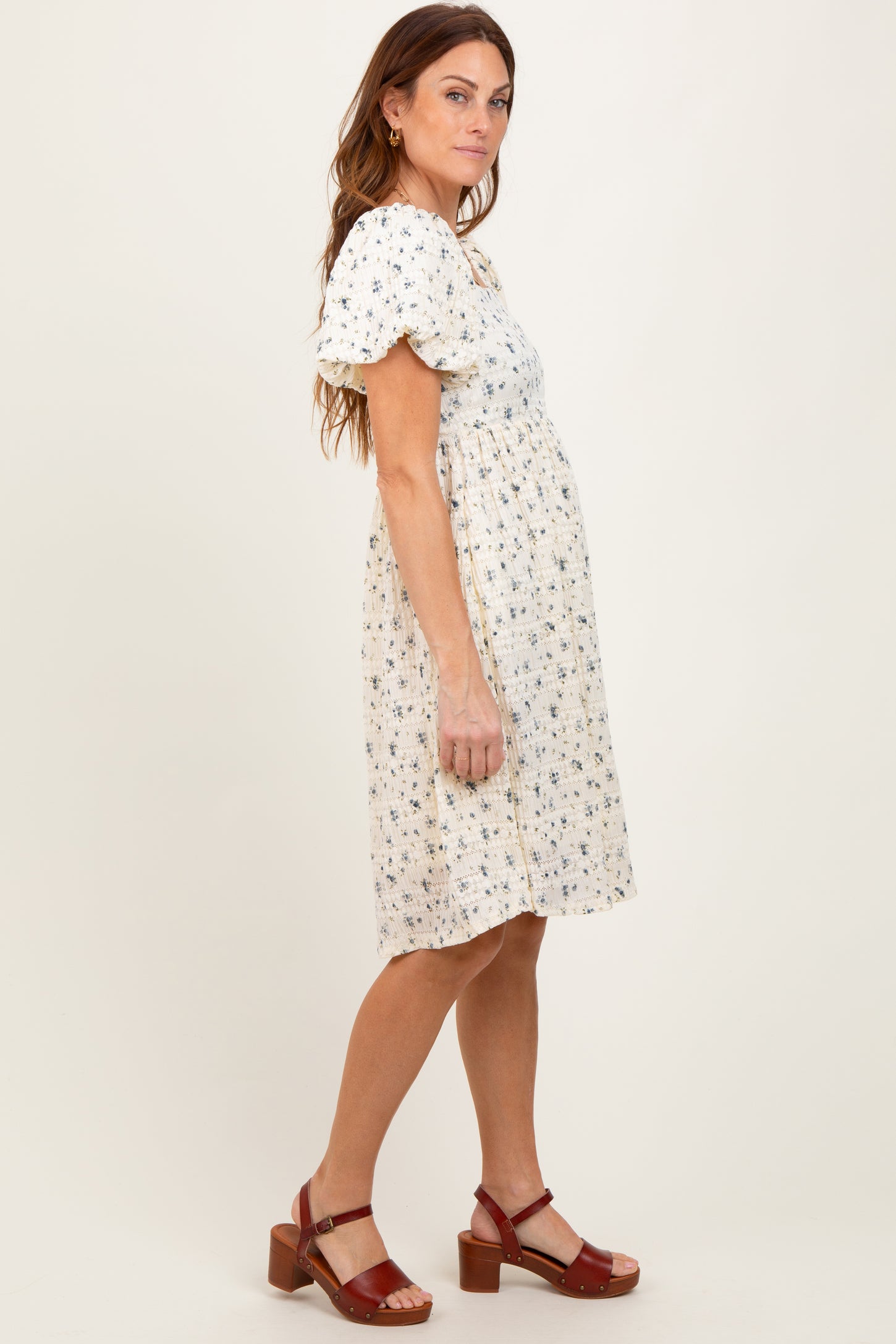 woman wearing a floral print short sleeve dress with a gathered waist and brown heeled sandals