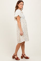 woman wearing a floral print short sleeve dress with a gathered waist and brown heeled sandals