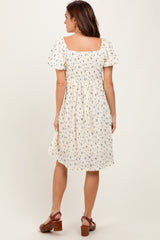 woman wearing a floral print short sleeve dress with a square neckline and a flowy skirt, shown from the back