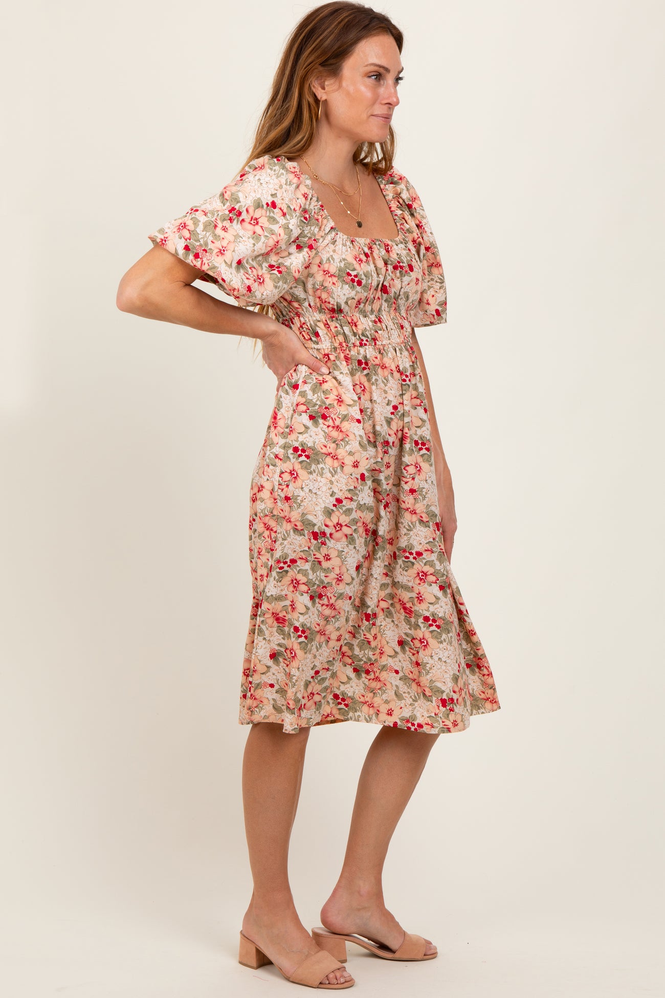 woman wearing a floral print midi dress with puff sleeves and a fitted waist in a side pose