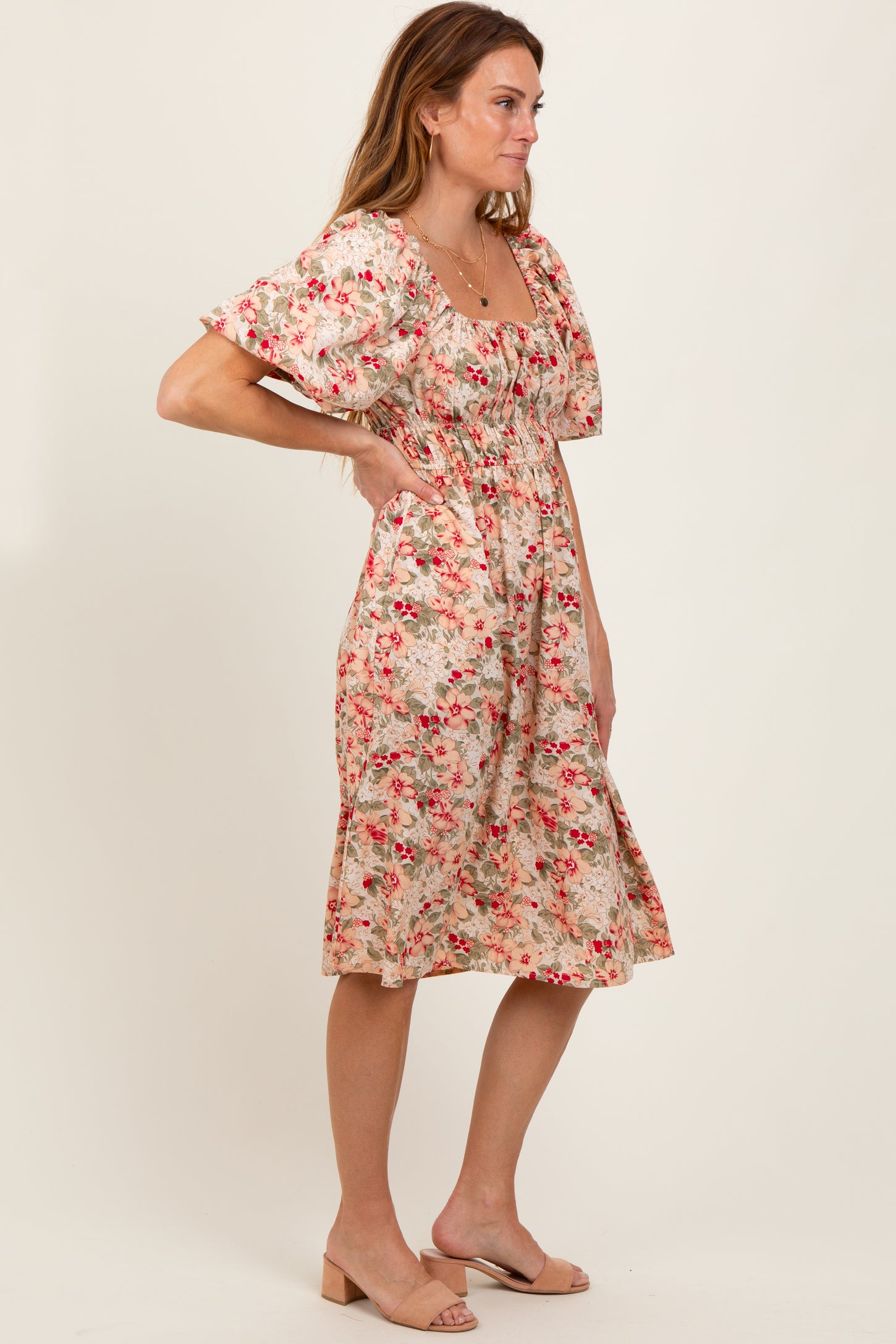 woman wearing a floral print midi dress with puff sleeves and a fitted waist in a side pose