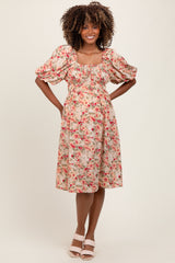 woman wearing a floral puff sleeve maternity dress with a fitted bodice and flowy skirt, baby bump visible