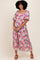 woman wearing a pink and blue floral maxi dress with short sleeves and a relaxed fit