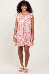 woman wearing a pink floral short sleeve dress with ruffle details and a button-down front