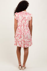 woman wearing a pink floral print short sleeve dress with ruffle details on the sleeves, seen from the back