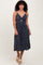 woman wearing a navy blue floral midi dress with a front twist and spaghetti straps
