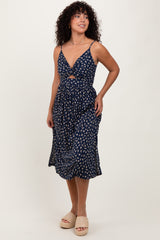 woman wearing a navy blue floral midi dress with a front cutout and adjustable straps