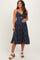 woman wearing a navy blue floral print maternity dress with a knot front and side slit, showcasing her baby bump