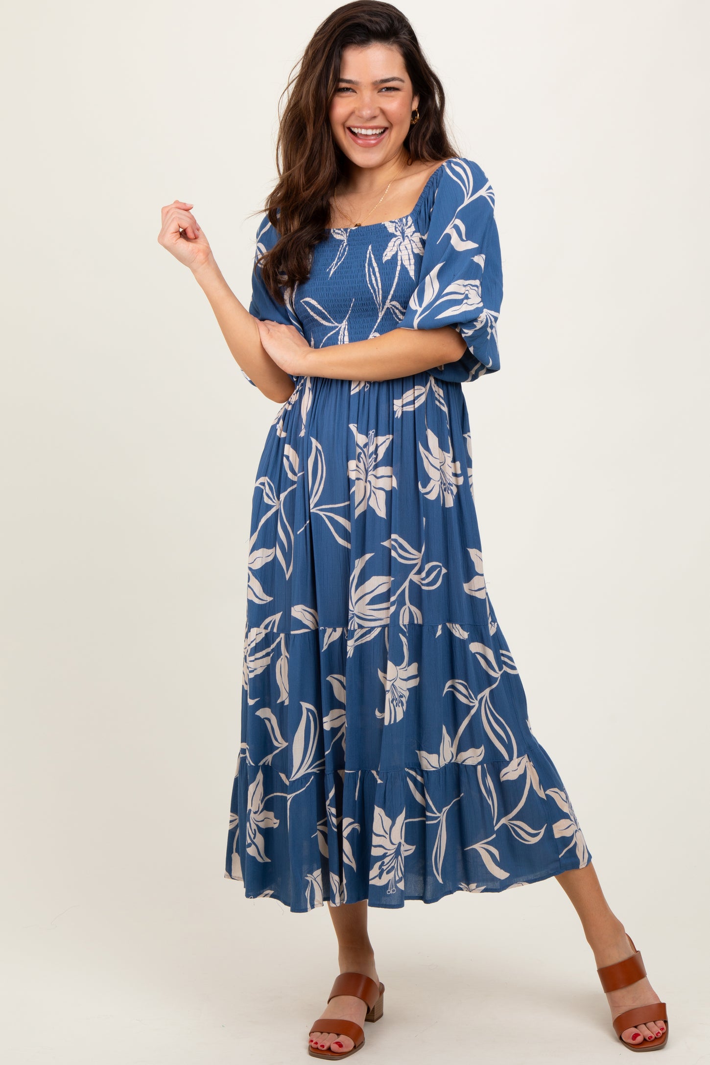 woman wearing a blue floral maxi dress with puff sleeves and a tiered skirt