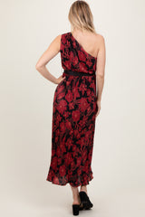 woman wearing a black and red floral one-shoulder maxi dress, showing the back view and a cinched waist