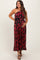 woman wearing a black and red floral one-shoulder maternity dress and holding her baby bump